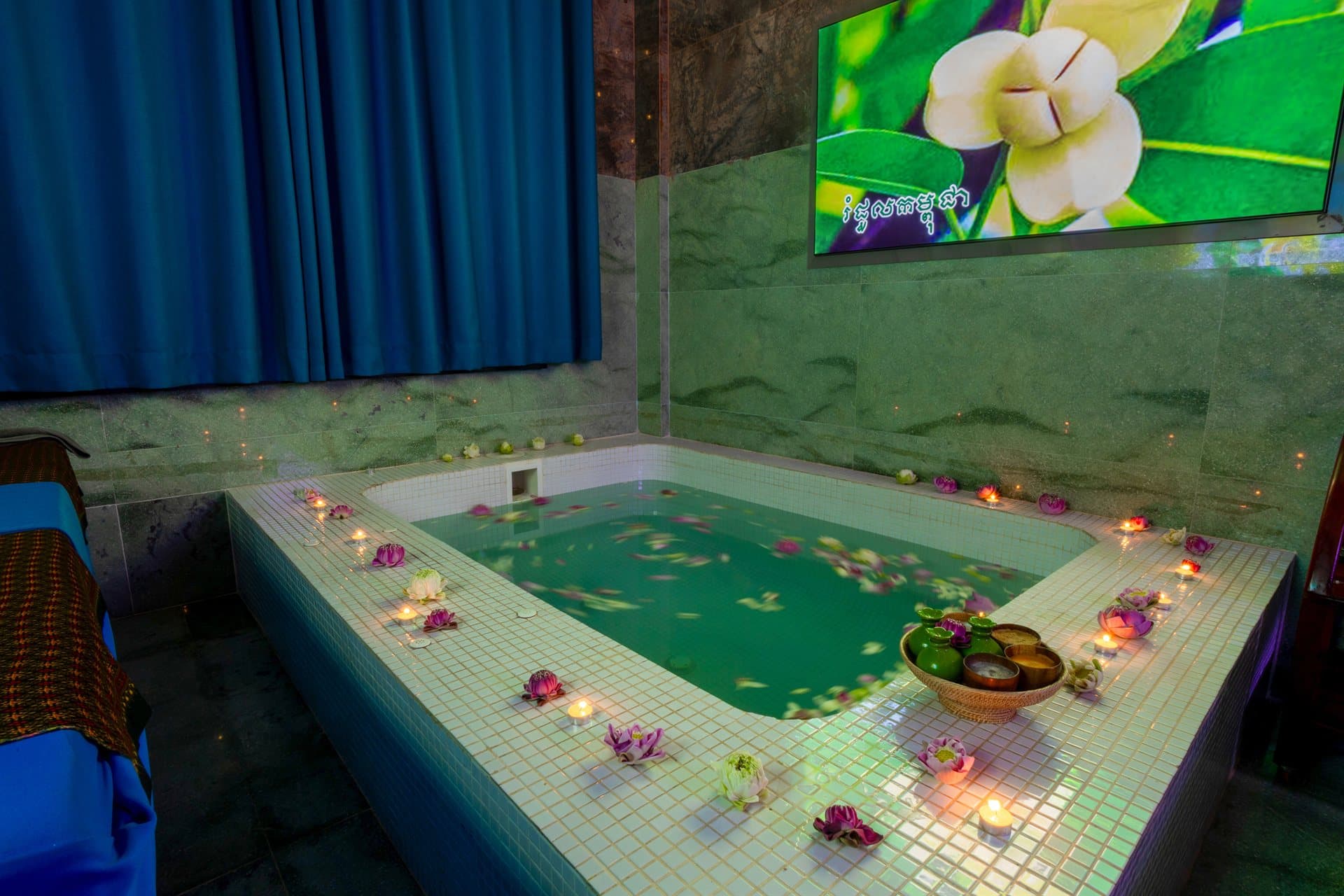 Teuk Spa sanctuary hydrotherapy bath with floating lotus flowers and candles